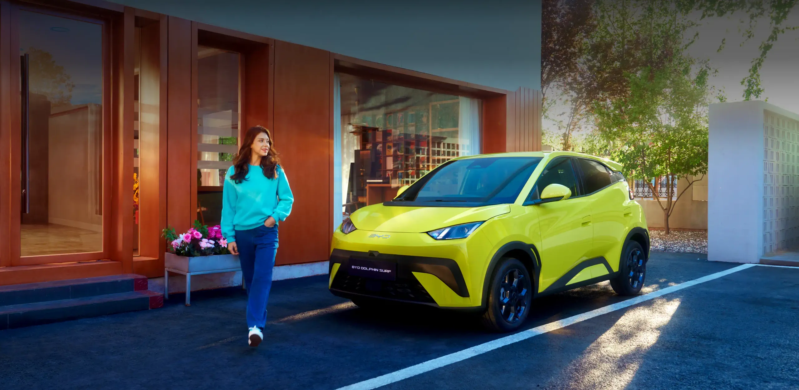 Novo BYD Dolphin Surf estacionado com mulher a passar à frente do carro
