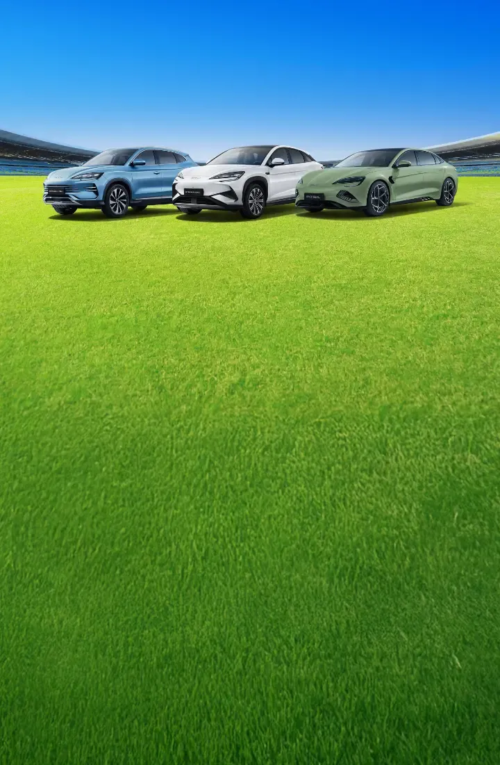 Três BYD's parados num revaldo de um estádio