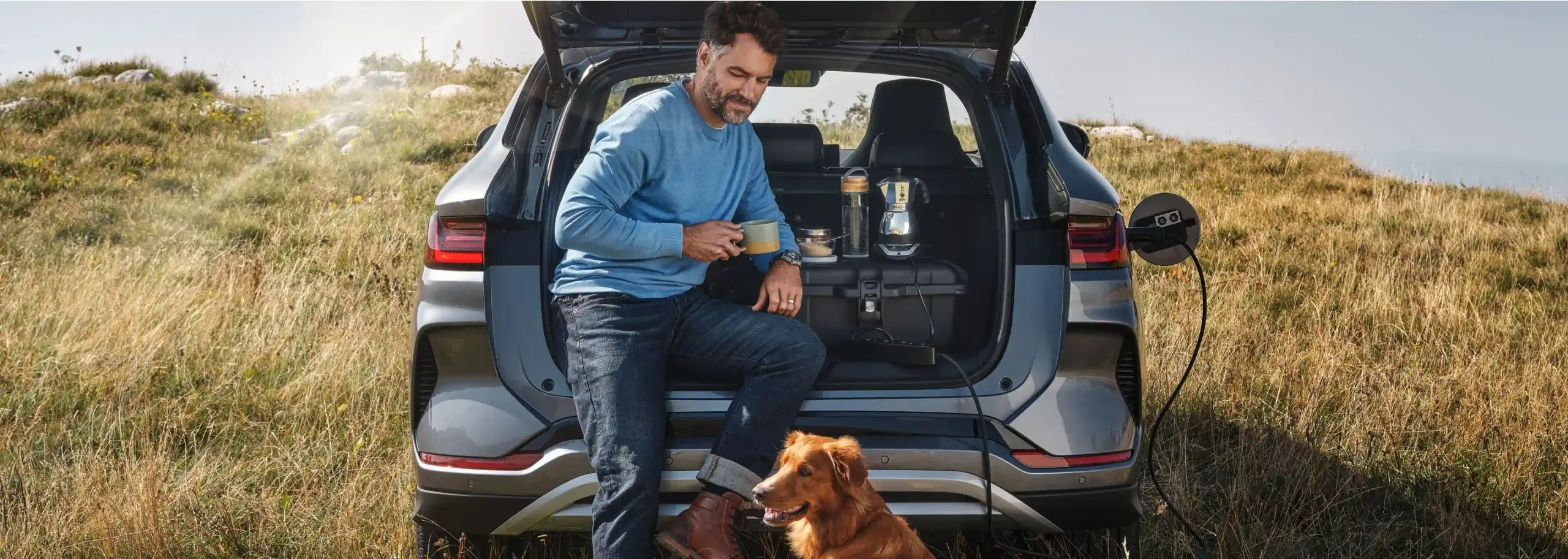 Homem com o seu cão encostado à bagageira do BYD SEAL U DM-i