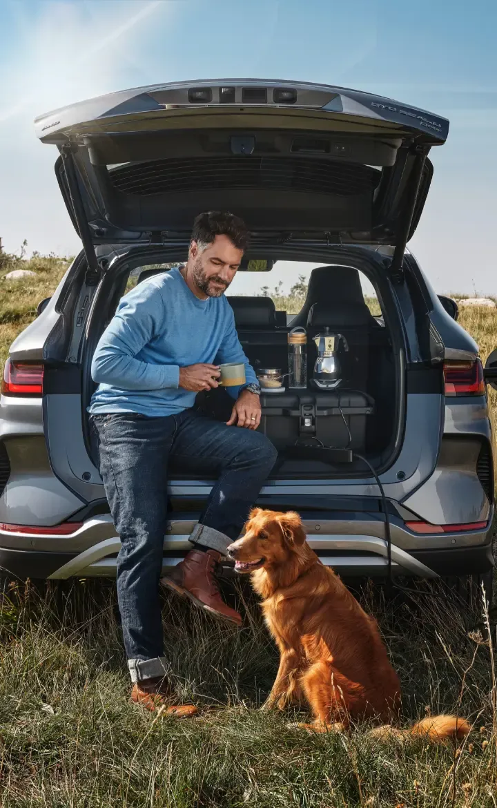 Homem com o seu cão encostado à bagageira do BYD SEAL U DM-i