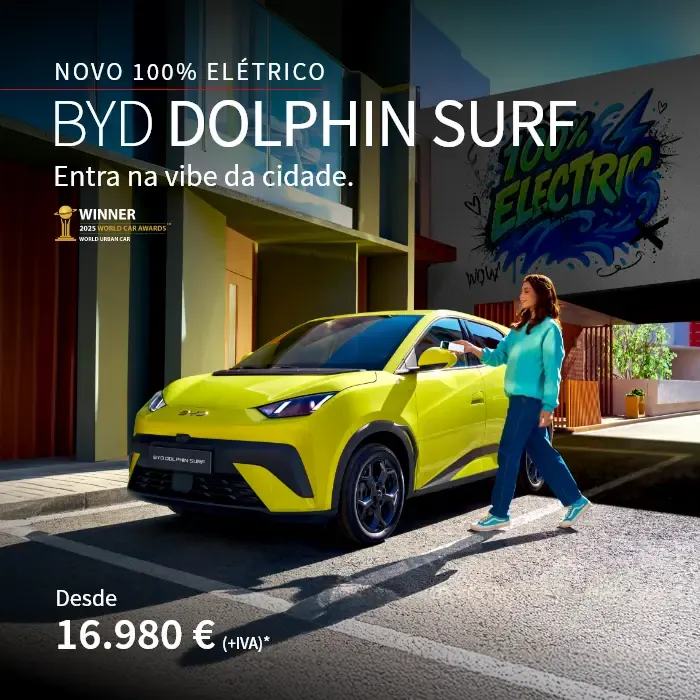 BYD DOLPHIN SURF parado na estrada com grafitis atrás e pessoa a abrir o carro